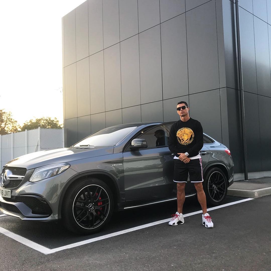 Cristiano Ronaldo standing in front of grey car