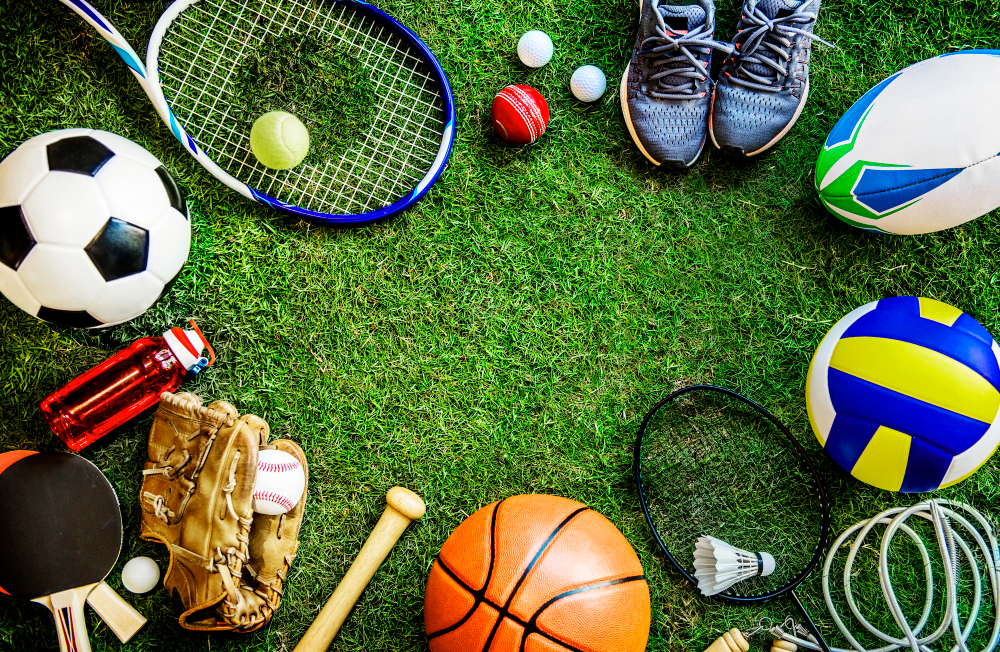 All types of sports equipment and accessories on green grass